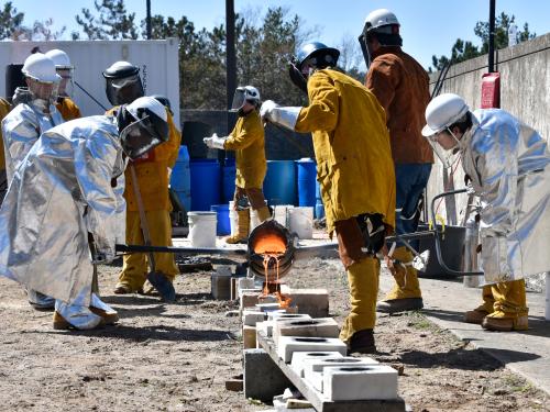 Students work with molten iron in the annual Iron Pour event