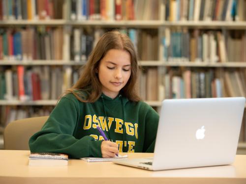 Student on a laptop in Penfield Library