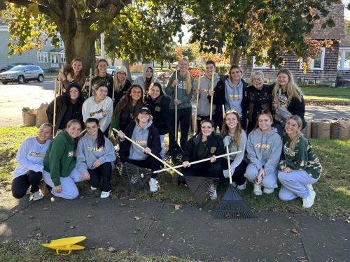 Laker field hockey team poses together after raking a yard