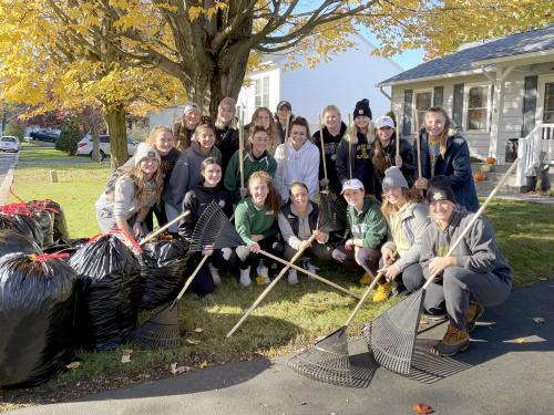 Laker student-athletes pose after raking leaves