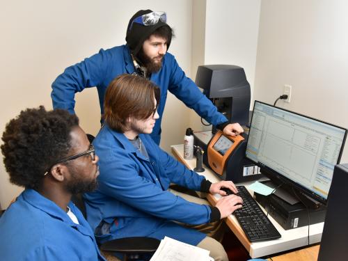 Student researchers (from left) Clinton Adu, Blake Britton and Muhammad Musozoda examine data.