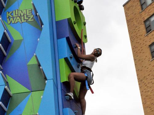 Student climbs an inflatable wall at OzFest