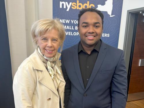 Irene Scruton, assistant dean of the School of Business and director of the university’s MBA programs, congratulates business administration major Price Flores for advancing to the statewide level of the New York State Business Plan Competition.