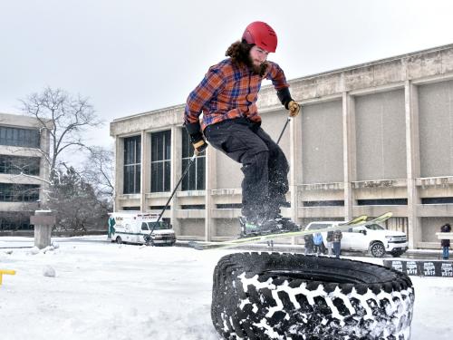 A skier jumps onto a large tire during a previous Rail Jam event