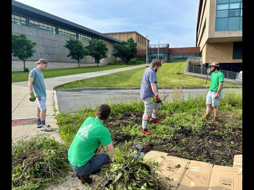 Students and staff members work in the Permaculture Learning Laboratory campus garden