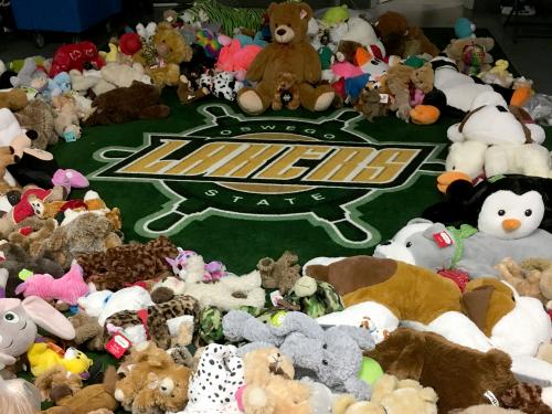 Stuffed animals ring a Lakers wheel logo in a hockey locker room