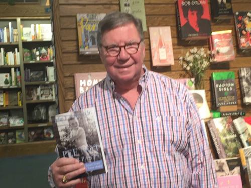 John Sullivan holding a book with many of his stories