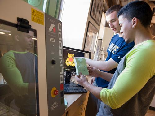 Two students using 3-D printer