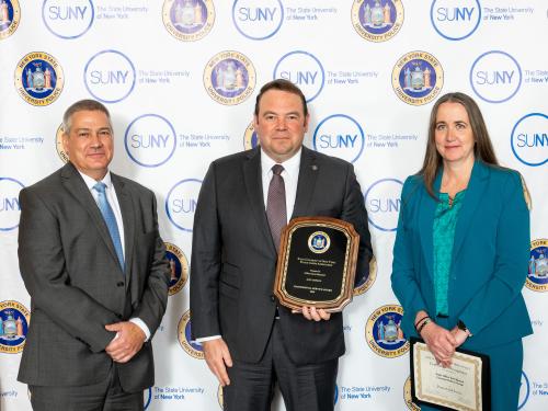 SUNY Oswego University Police Chief Scott Swayze accepts a SUNY award on behalf of Officer Scott Maynard