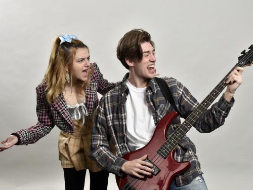 Rachel Leotta, at left, and Brock Whaley, at right playing a bass, are among the ensemble cast of The Wedding Singer