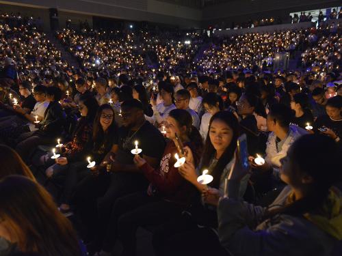 Students hold up candles at Torchlight