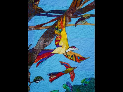 A multicolor community-created quilt that uses birds as a metaphor for the Black experience in America