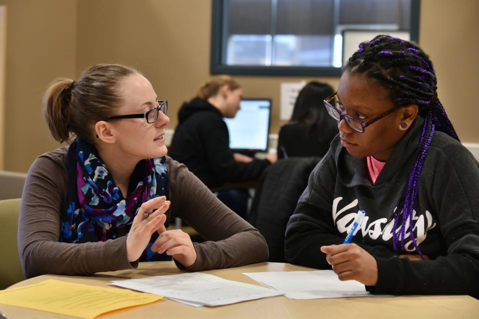 A tutor and tutee work together to revise a paper.