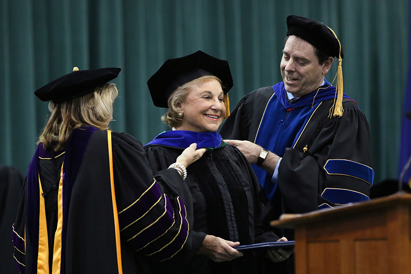 College President Deborah F. Stanley (left) and Provost Scott Furlong arrange the hood of community leader and philanthropist Noreen Reale Falcone, recipient of SUNY’s doctorate in humane letters