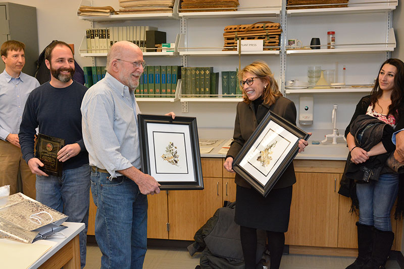 Andrew Young accepts framed displays of dried flowers from college President Deborah F. Stanley