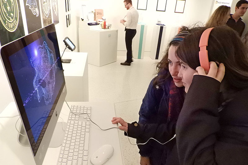 Students listen to headphones at exhibition