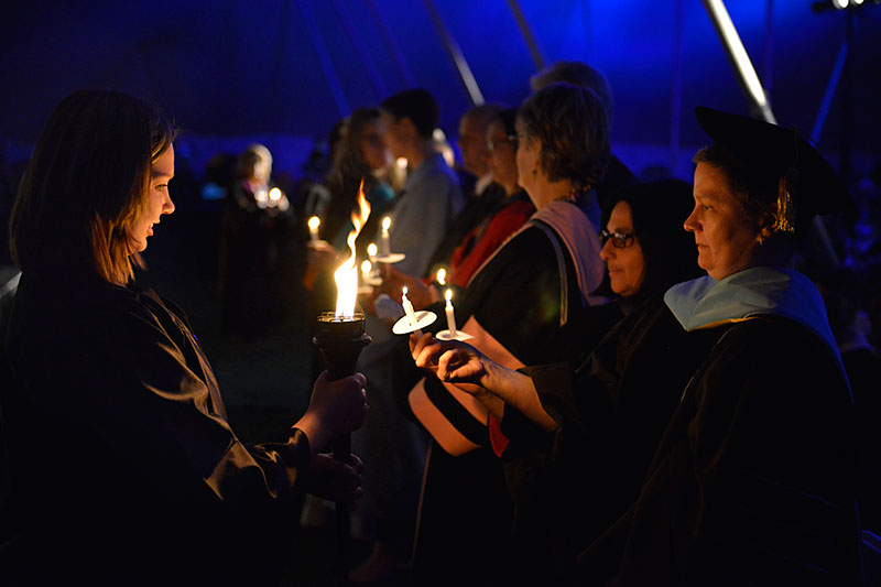 Torchlight participants light candles