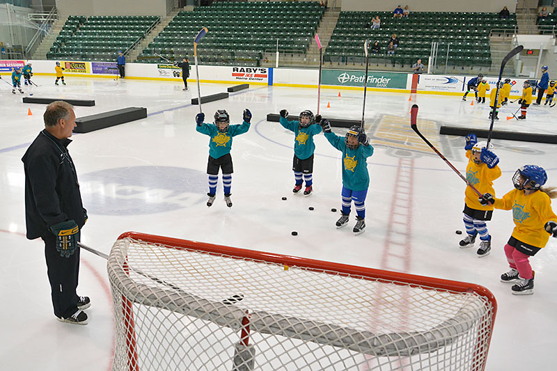 Coach Ed Gosek with young hockey players