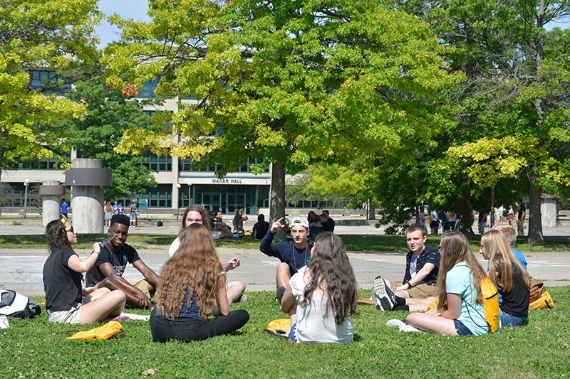 Laker Leaders and students sit on grass