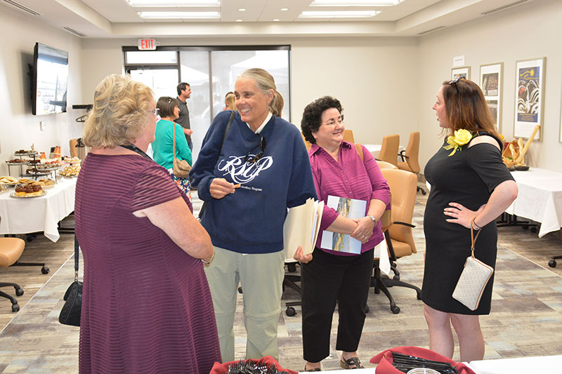 Attendees speak to each other at Open House for SUNY Oswego's Office of Business and Community Relations new locations