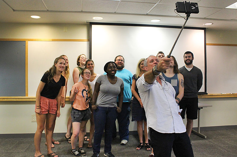 Paul Austin uses selfie stick to take photo with students