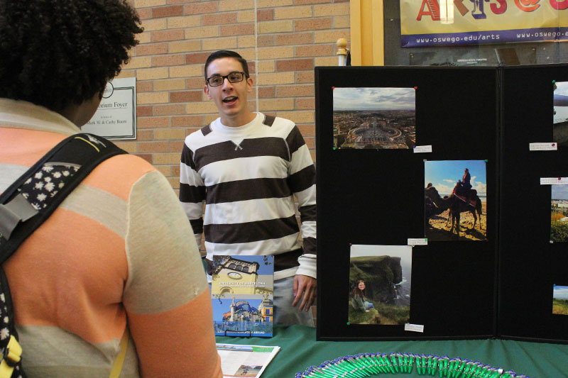 Student Tom Hardman speaks with visitors at Study Abroad Fair