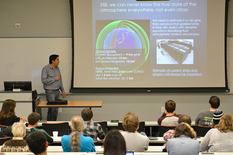 Alumnus Michael Coniglio, class of 1997 and research meteorologist for the National Severe Storm Labs, shares a projected slide about earth's atmosphere