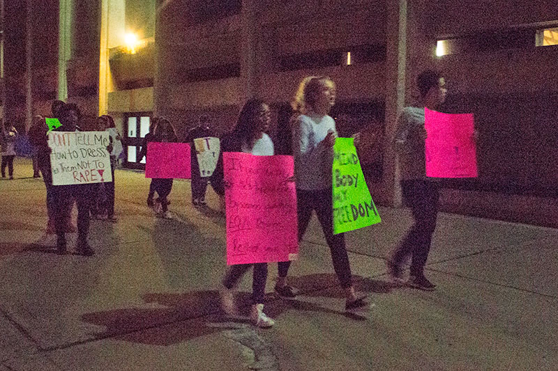 Students carrying signs take part in Take Back the Night march