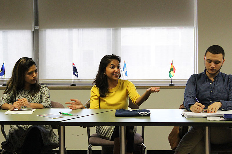 Keynote speaker Shalini Kantayya, a filmmaker and eco-activist, speaks while flanked by Oswego students