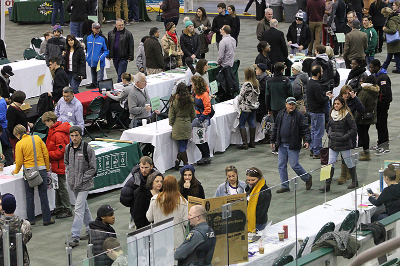 High school students and family members browse and ask questions at information tables