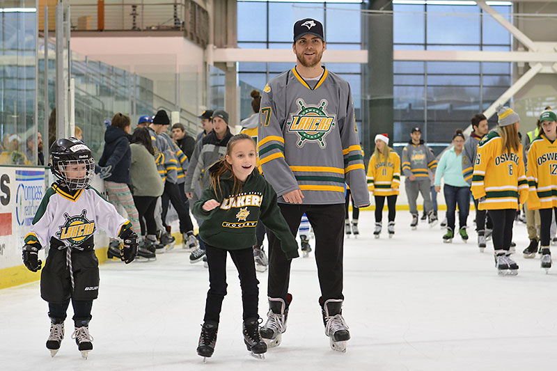 Laker hockey players skate with young fans