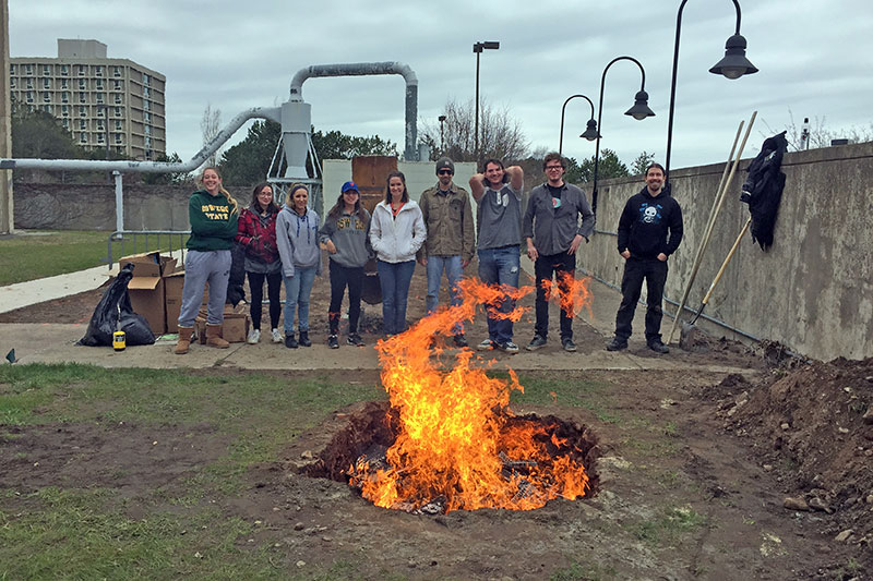 Students pit-firing ceramics