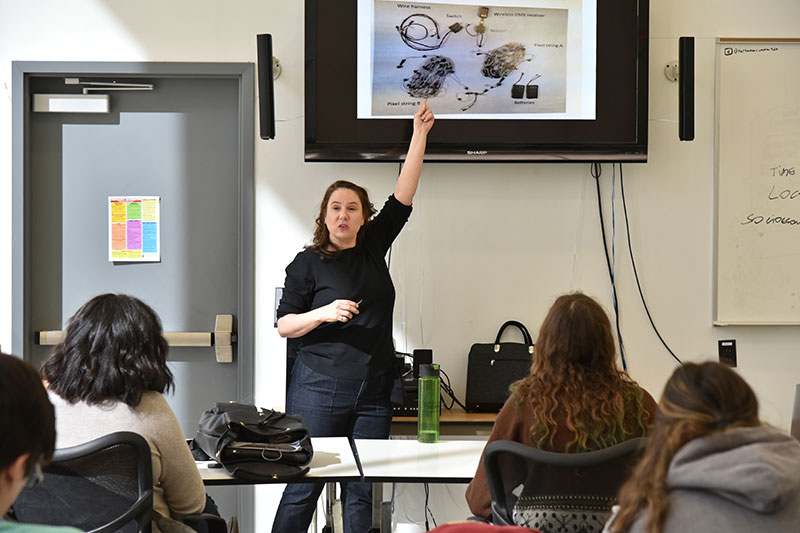 Alumna Dawn Marcoccia presenting on stage electronics and mechanics