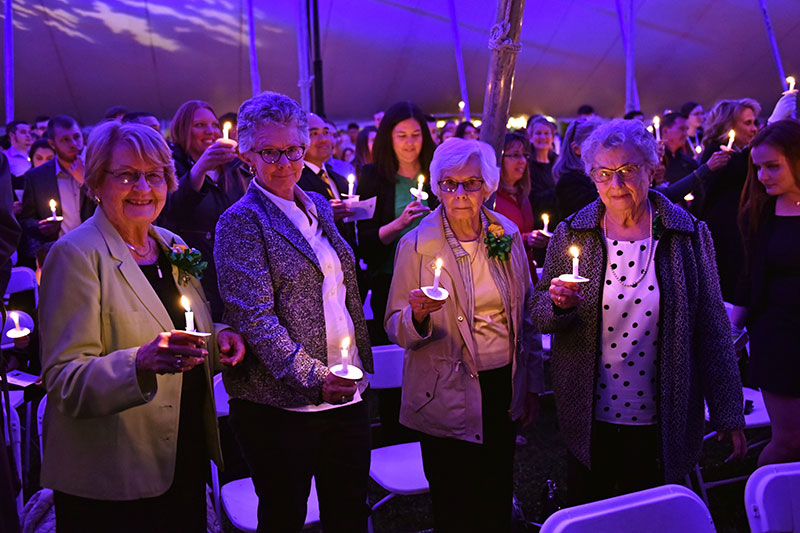 Alumni holding candles at Torchlight