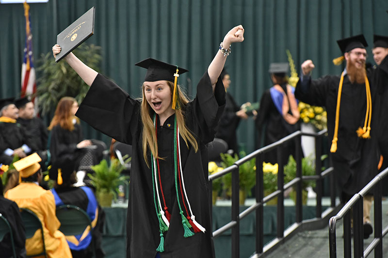 Kimberly Smith celebrates as she comes down the ramp at Commencement