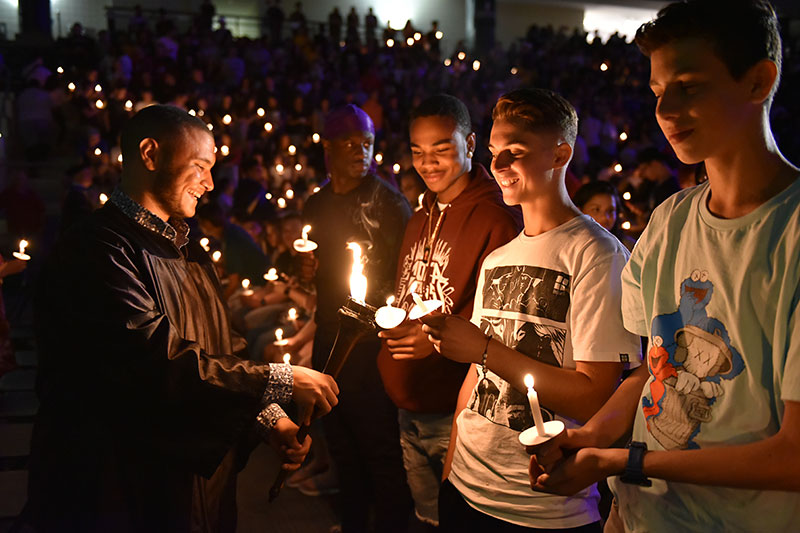 Students hold candles during Opening Torchlight