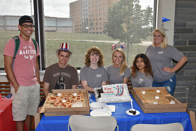 Constitution Day student volunteers with pizza and cake