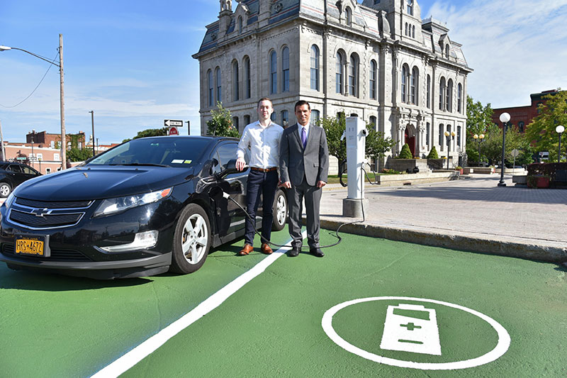 SUNY Oswego student Alex Chambers and Oswego Mayor William J. Barlow Jr. with electric car charging station