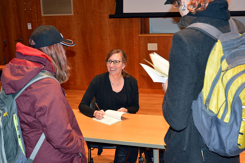 Poet Rebecca Dunham signs copies of her Cold Pastoral collection for audience members