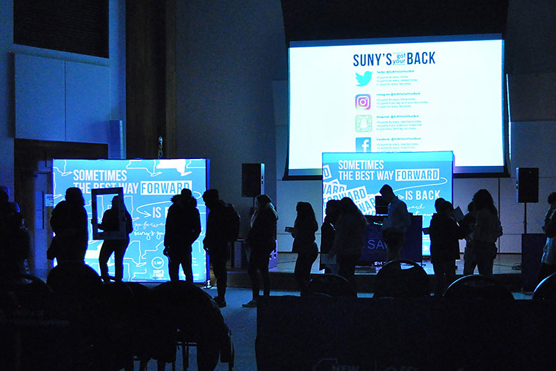 Silhouetted students work on filling bags in the SUNY's Got Your Back event