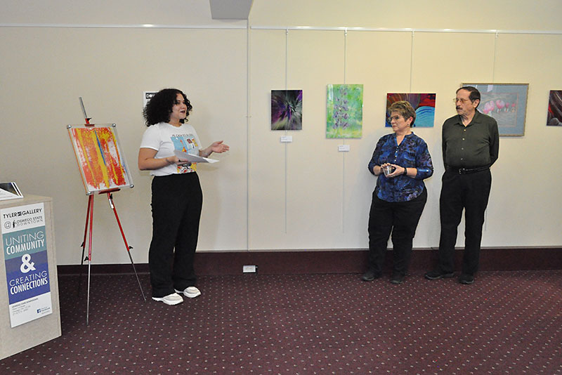 Sally Familia offers a poem at art exhibition opening