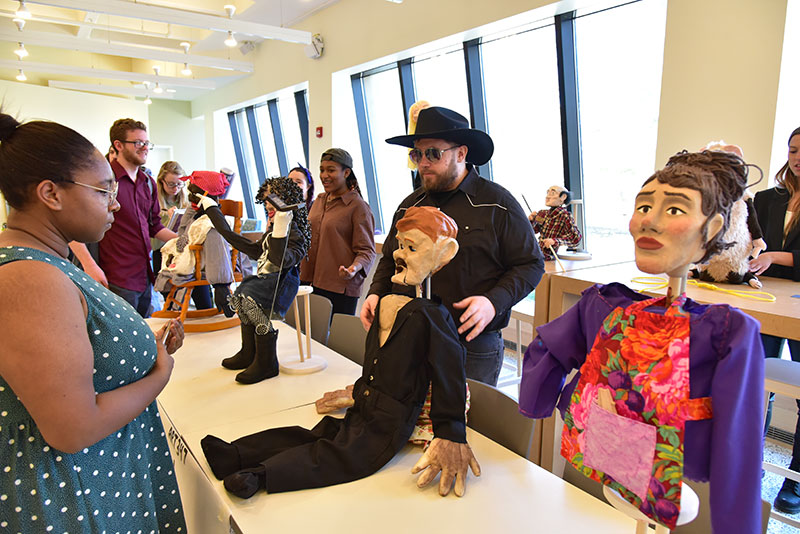 Studio art major Nate Canfield displays the puppets he sculpted