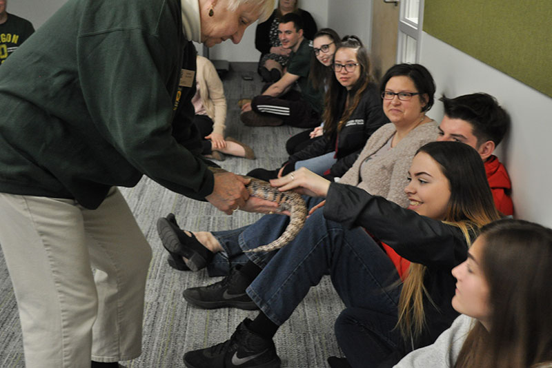 Zoo volunteer lets Focus Forward students touch a live skink