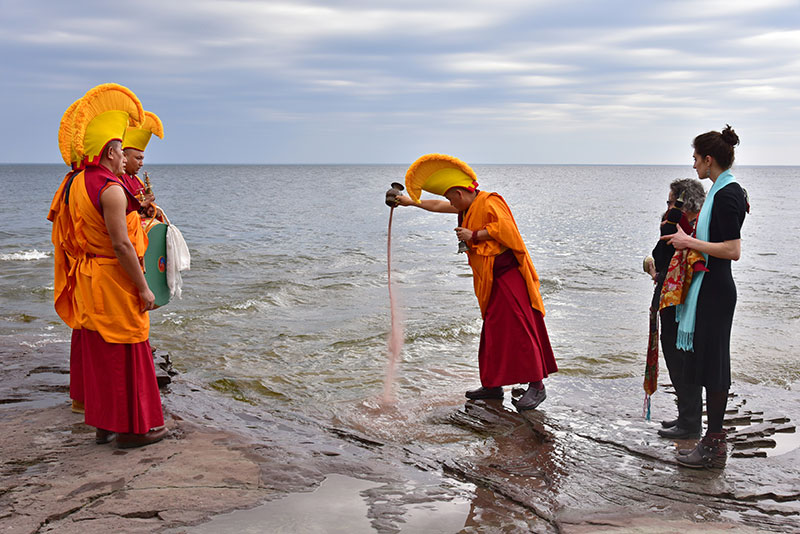A Drepung Loseling monk pours colored sand into Lake Ontario as part of the closing ceremony of "The Mystical Arts of Tibet"