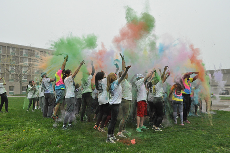 A powdery rainbow soars over Color Oswego participants and volunteers