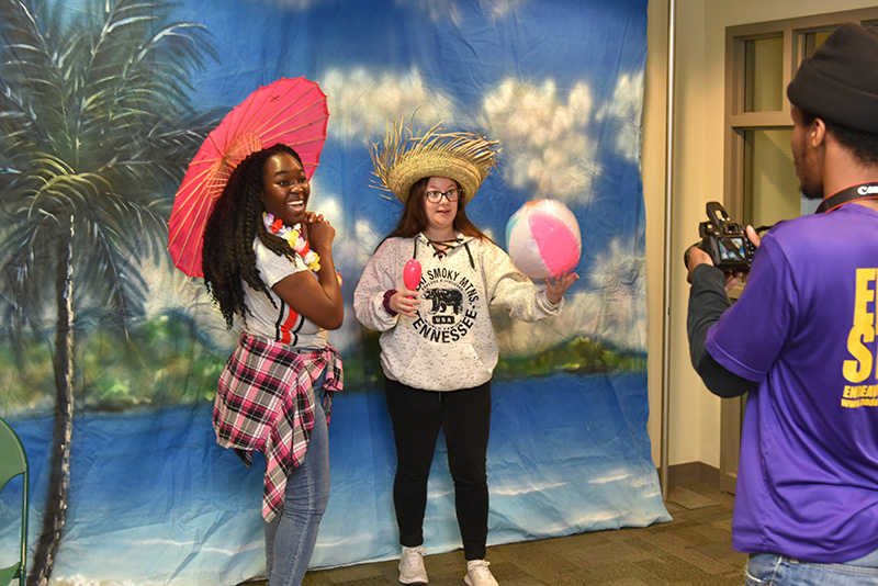 Students Shyanne Reid (left) and Ashley Savage have their photo taken in tropical style at OzFest’s photo booth