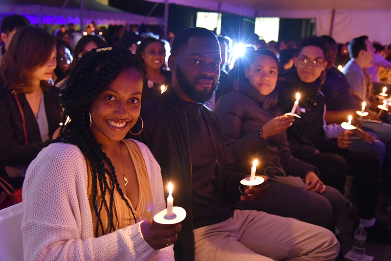 Skye Prosper (foreground), displays the Torch of Learning, a flame passed among her fellow graduating seniors at the Torchlight Ceremony