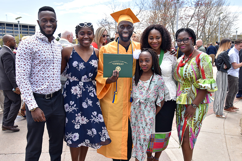 Family members surround finance major and economics minor Dillon Nimako following Commencemen