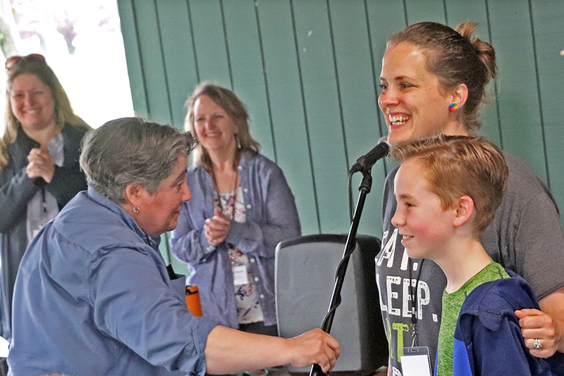 Art professor Cynthia Clabough (left in front) congratulates Frederick Leighton Elementary School student Gus McDonald for his art's inclusion in the My Hometown Banner project