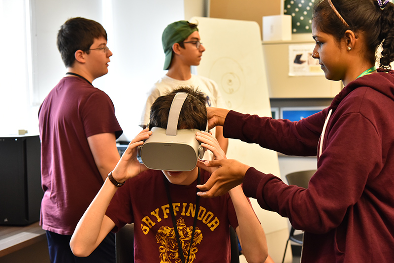 Yavuz Damkaci, of the Sheldon Institute senior division, tries out virtual reality goggles for a virtual roller coaster ride